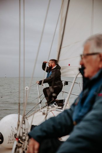 Deux membre d'une même famille à bord de Kelone qui regardent ensemble vers le large.